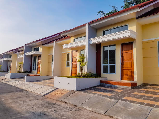 A row of modern, single-story yellow and gray housing units in Indonesia, showcasing the impact of foreign housing investment in driving the country's ambitious 3 million homes program under President Prabowo Subianto.