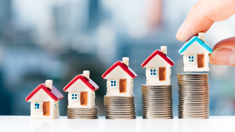Stacked coins with small model houses representing the Characteristics of Investment-Worthy Property, illustrating real estate investment potential and value growth.