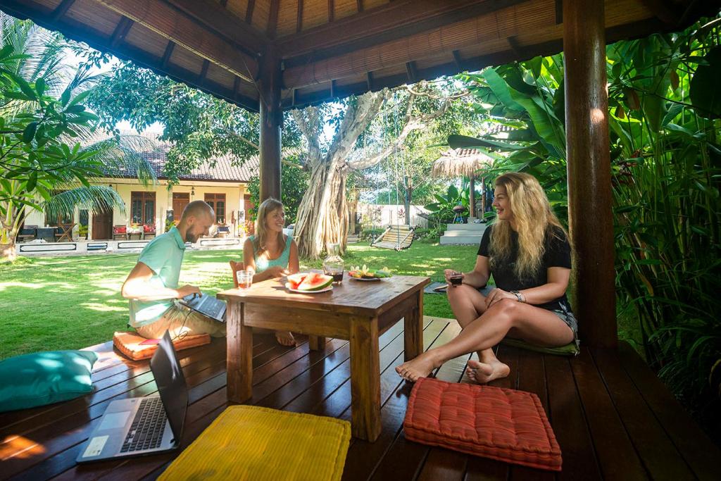 Communal space at a boarding house in Bali with people working and socializing.