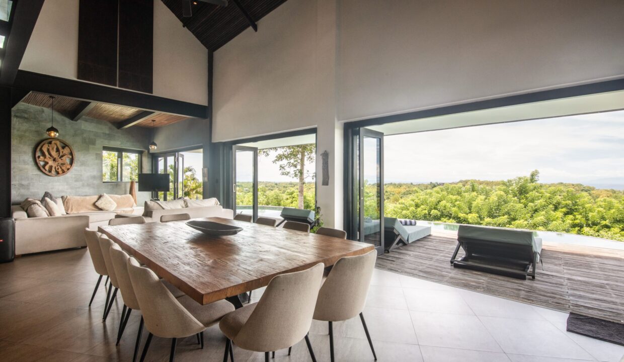 Spacious modern villa interior with open dining and living area overlooking greenery, showcasing the Bali real estate market luxury.
