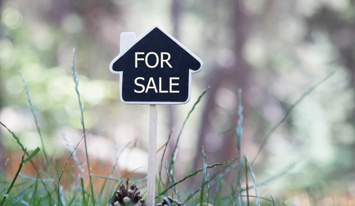 Small house-shaped sign with the words “For Sale” placed in the grass, symbolizing Bali houses for sale.