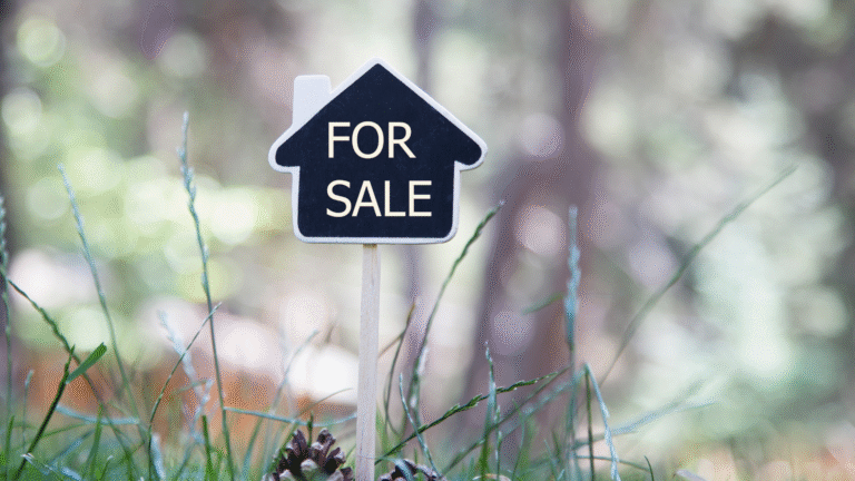 Small house-shaped sign with the words “For Sale” placed in the grass, symbolizing Bali houses for sale.