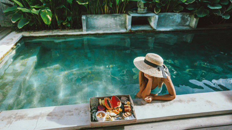 A woman relaxing by a private pool with tropical fruit breakfast at a luxury villa — representing the comfort and lifestyle of a long-term villa rental in Bali.