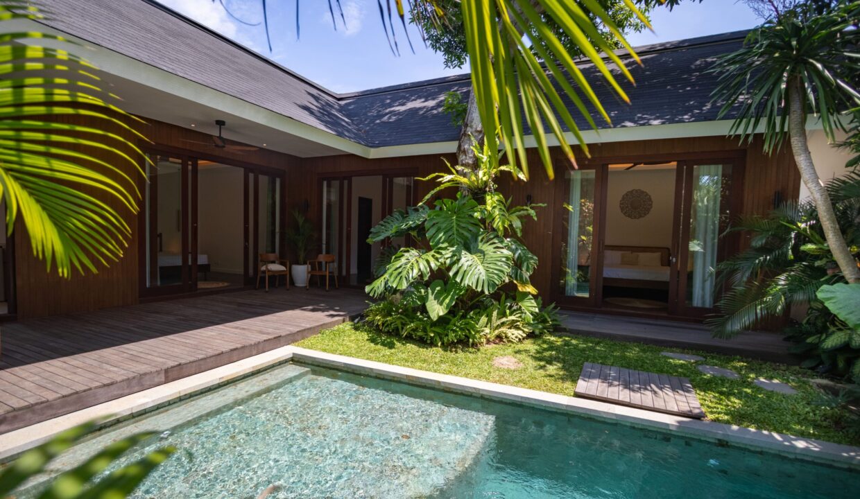 A modern tropical villa with a private pool, wooden deck, and lush garden, showcasing a peaceful retreat ideal for investors searching for an underrated property in Bali.