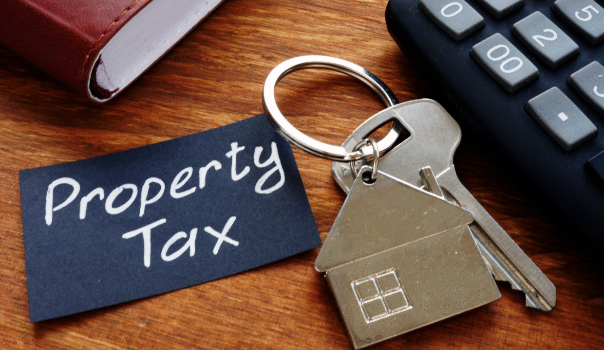 House-shaped keychain and calculator on a desk representing property taxes in Bali.