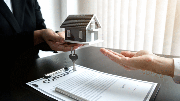 A person handing over house keys and a miniature home model above a signed document, illustrating a Villa Rental Contract in Indonesia.