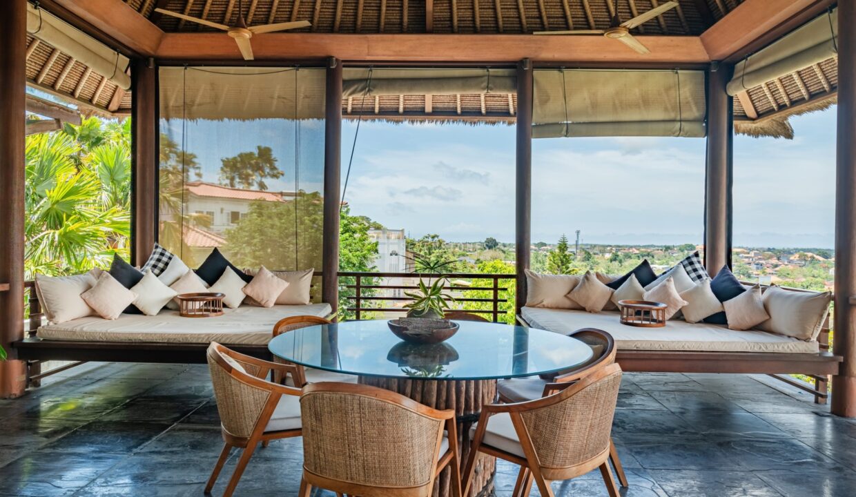 Luxury villa in Bali ideal for buying furniture in Bali, featuring open-air living space, rattan chairs, and tropical views.