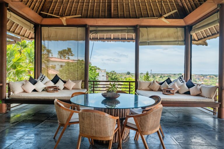Luxury villa in Bali ideal for buying furniture in Bali, featuring open-air living space, rattan chairs, and tropical views.
