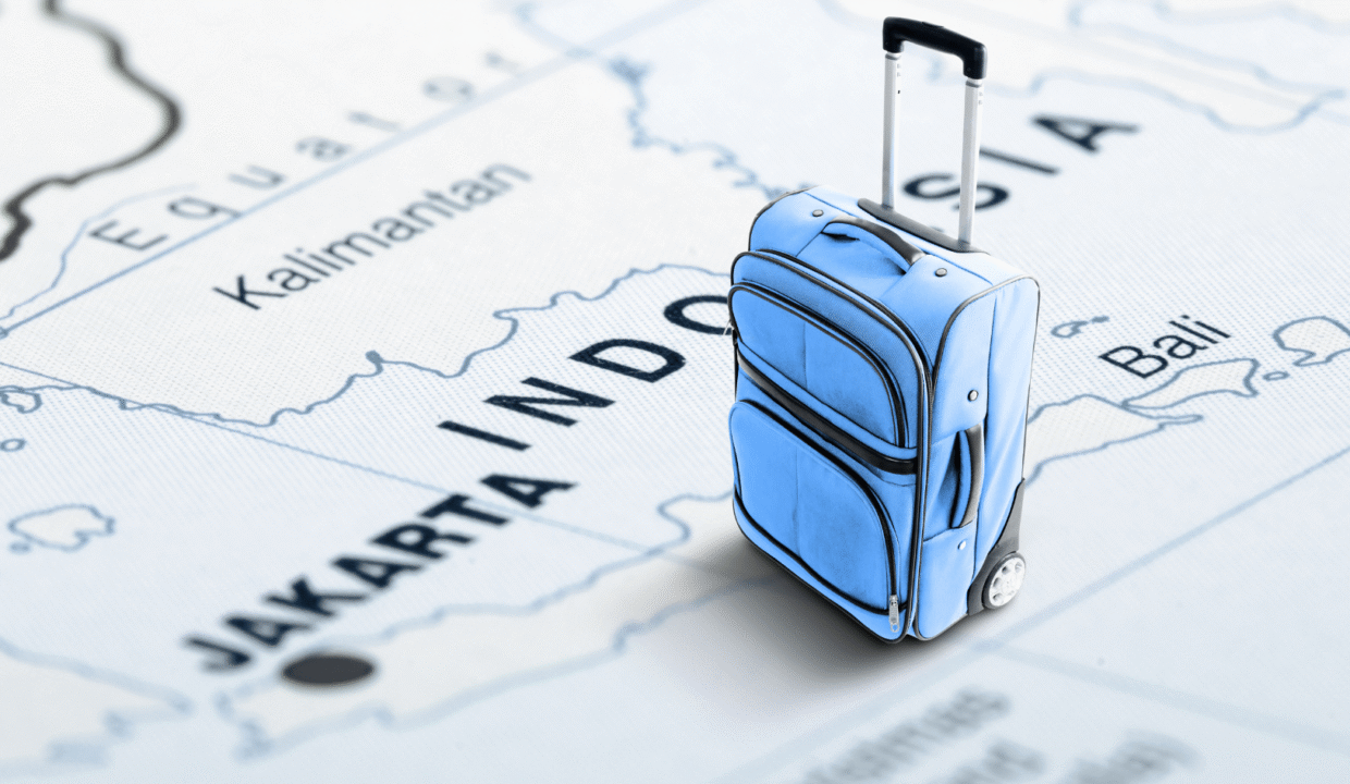 A blue suitcase standing on a map of Indonesia, symbolizing travel and relocation for jobs in Indonesia for foreigners.