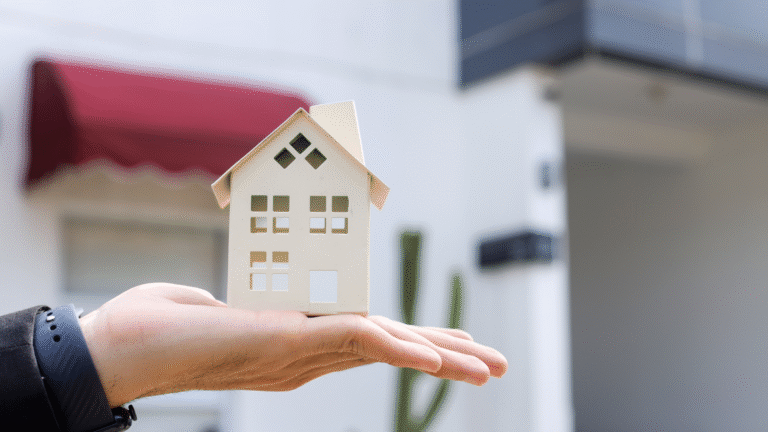 A person holding a small model house outdoors, symbolizing property ownership in Bali for Australians and real estate investment opportunities.
