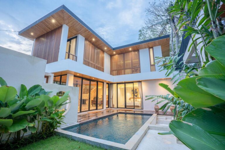 A modern tropical villa with wood accents, large windows, and a private pool, showcasing Bali villa design trends in 2026.