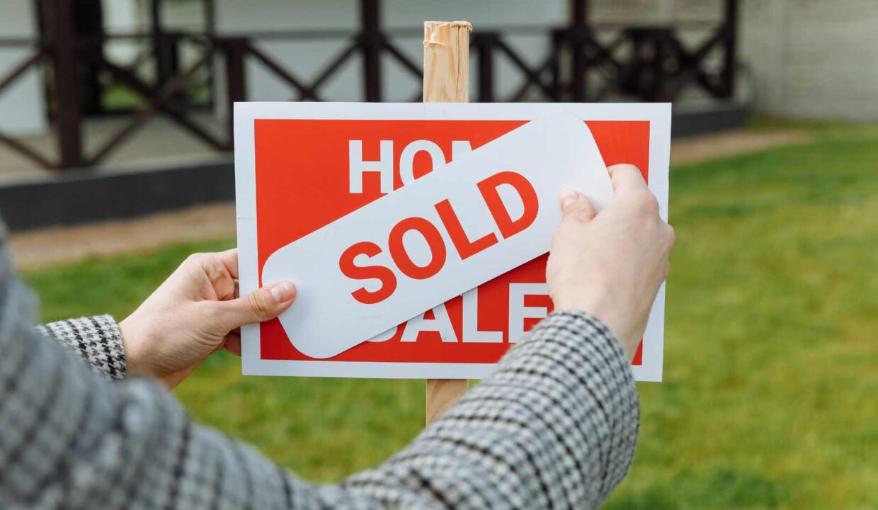 A buyer places a sold sign on a home for sale, symbolizing successful real estate transactions and interest to buy property in Ubud.