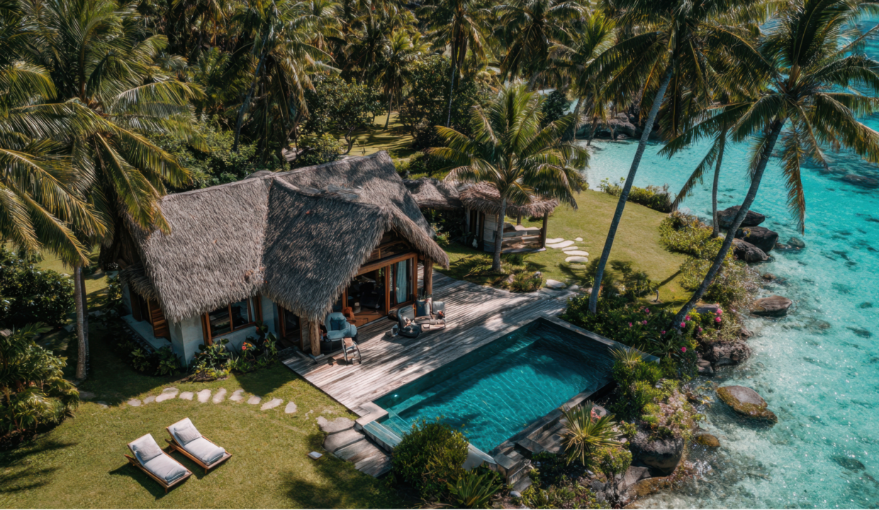 Tropical beachfront property in Bali with thatched villas, private pool, palm trees, and turquoise water.