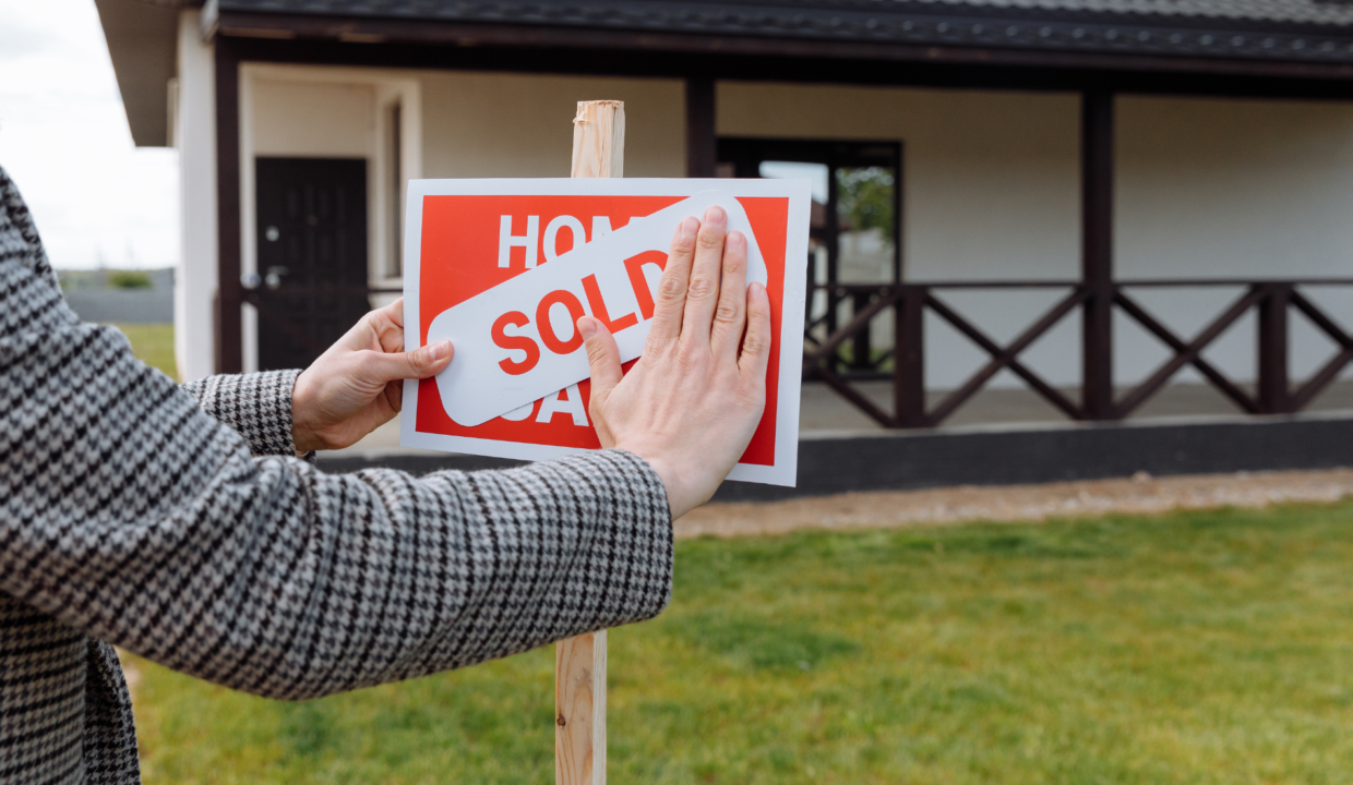 Foreign investor placing a “Sold” sign in front of a villa, representing the question can foreigners buy property in Bali and legal ownership options.