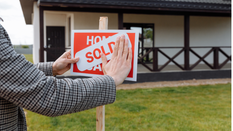 Foreign investor placing a “Sold” sign in front of a villa, representing the question can foreigners buy property in Bali and legal ownership options.